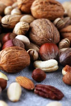 Mixed nuts on grey background. Healthy food and snack. Walnut, pecan, almonds Stock Photos