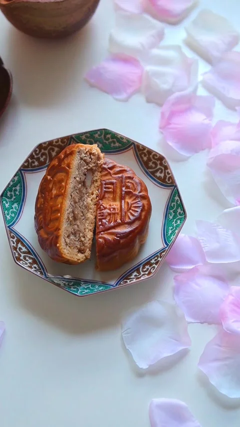Mixed nuts mooncake with Cherry blossom petals scattered on a white background Stock Footage 320326025