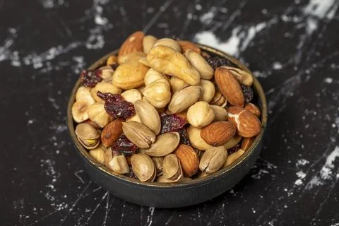 Mixed nuts. Nuts, pistachios, peanuts, almonds, cashews. Mixed nuts on dark b Stock Photos