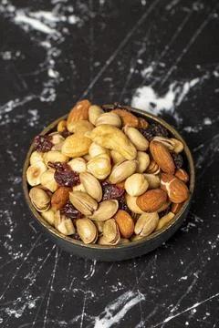 Mixed nuts. Nuts, pistachios, peanuts, almonds, cashews. Mixed nuts on dark b Stock Photos