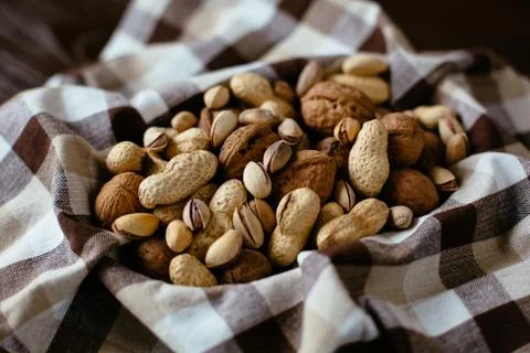 Mixed nuts on towel. Group of different nuts: peanut, pistachio, walnuts. Org Stock Photos