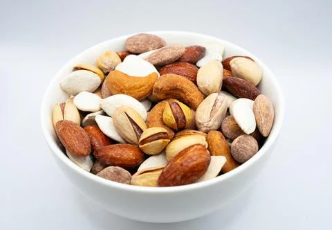 Mixed nuts in white bowl isolated healthy eating and protein snack concept Stock Photos