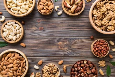 Mixed nuts in wooden bowl. Mix of various nuts on colored background. pista.. Stock Photos