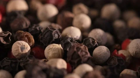 Mixed peppercorns falling in rotation, heap of spice, mix of different peppers Video stock 166388626