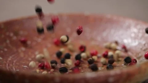 Mixed peppercorns falling into rustic kitchen in slow motion and close-up Stock Footage 141096450