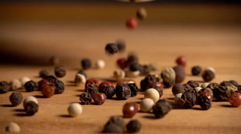 Mixed peppercorns falling onto table in slow motion Stock Footage 61690878