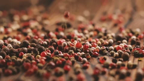 Mixed peppercorns falling on wooden table, 240 fps slow motion Video stock 131723806