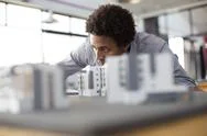 Mixed Race Architect Examining Architectural Model In Office Stock Photos