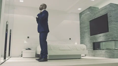 Mixed race banker gets ready for work in penthouse apartment then uses tablet Stock Footage 105010779