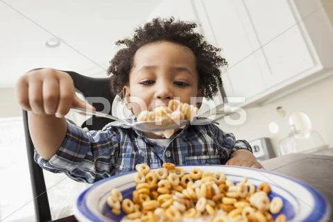 Mixed Race Boy Eating At Table