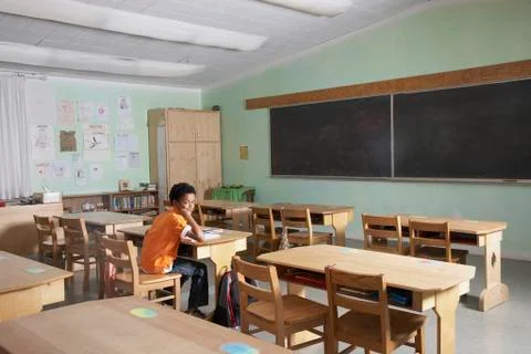 Mixed Race boy in empty classroom Foto stock