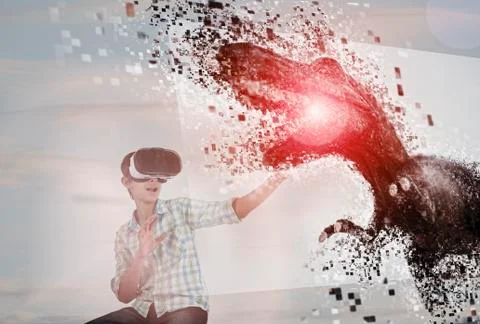 Mixed Race boy using virtual reality goggles watching dinosaur Stock Photos