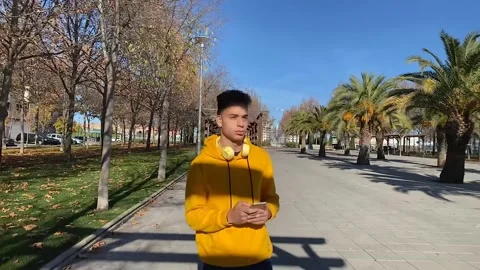 Mixed race boy walking and looking at his cell phone. Stock Footage 148786625