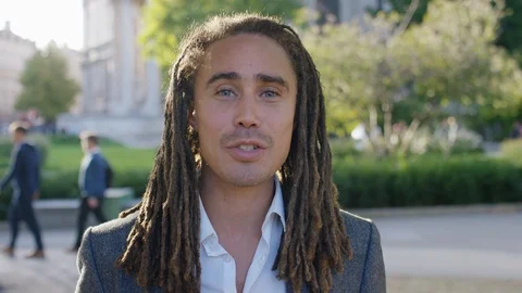 Mixed race businessman with dreadlocks talking to camera Video stock 116349191
