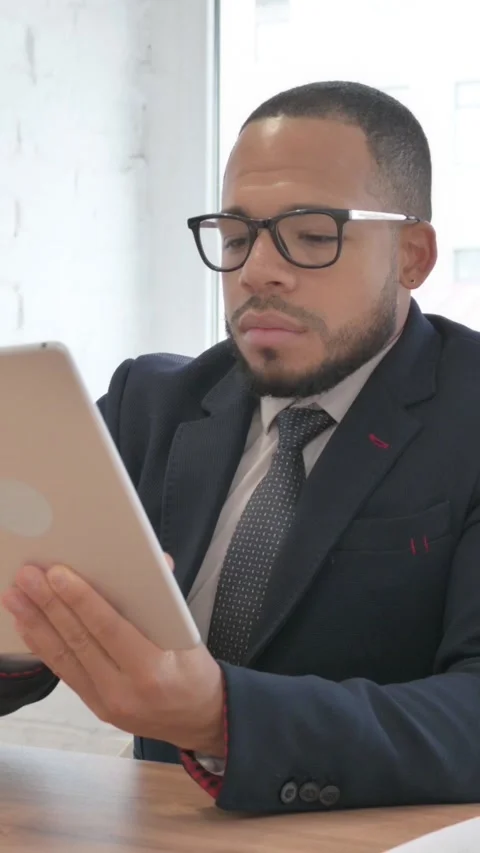 Mixed Race Businessman Using Digital Tablet in Office, vertical video Vidéo 325695531