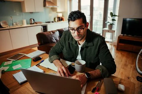 Mixed race businessman working on laptop sitting at home office Stock Photos