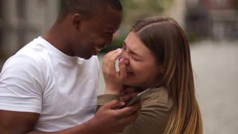 Mixed race couple date. Interracial couple having fun with smartphone in the Stock Footage 132999353