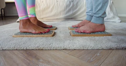 Mixed race couple stands on Sadhus boards with sharp nails opposite each other Stock Footage 166265406