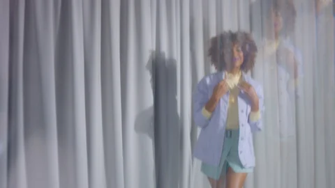 Mixed race dancer on grey curtains in pastel colors clothes dancing and video Video stock 127040931