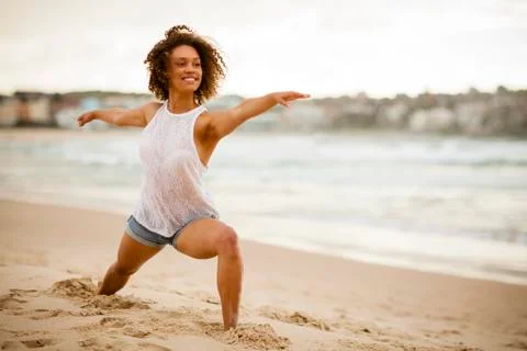 Mixed-race dancer stretching on the beach Stock Photos