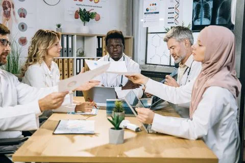 Mixed race doctors sharing with knowledges during meeting Stockfoto's