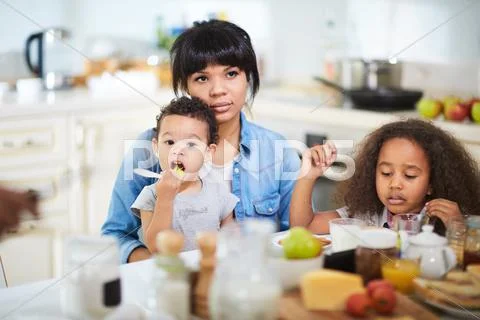 Mixed-race family having breakfast in the kitchen Stock Photos