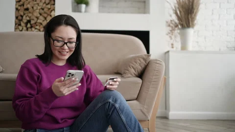 Mixed race female client holding banking credit card and smart phone involved in Stock Footage 169069041