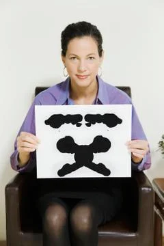 Mixed race female psychiatrist holding ink blot Stock Photos