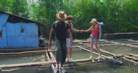 Mixed race friends walking on net walkways on fish farm tour in Asia Thailand. S Vídeo Stock 201095949