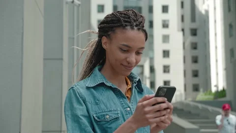Mixed race girl jacket using Smart phone outdoors of the business center the Stock Footage 160036643