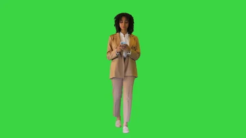 Mixed race girl walking and using smart phone on a Green Screen, Chroma Key. Stock Footage