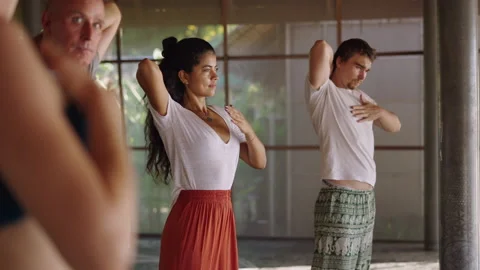 Mixed race group in healing class pat their head and chest to move the energy Stock Footage 217438476