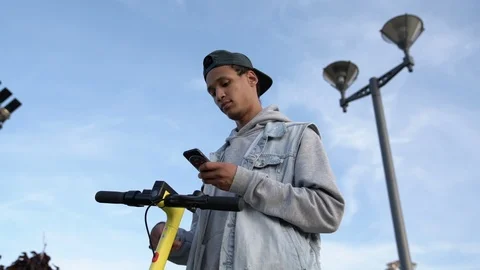 Mixed race guy share electric scooter in the city, view from down to up Stock Footage 115757036
