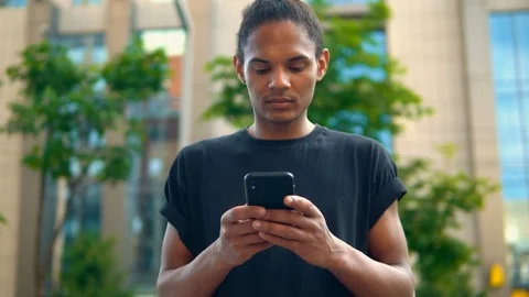 Mixed race guy typing message on mobile on the run Stock Footage 127866610