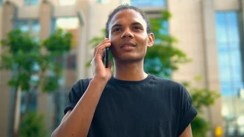 Mixed race guy using mobile on the run Stock Footage 127868879