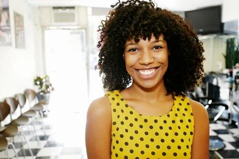 Mixed race hairstylist smiling in salon Stock Photos