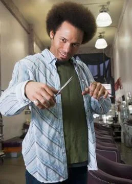 Mixed Race male hair stylist holding scissors Stock Photos