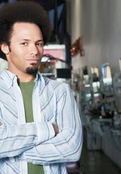 Mixed Race male hair stylist with arms crossed Stock Photos