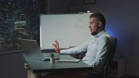 Mixed-race man with beard starting online video conversation on computer at Stock Footage 157600877