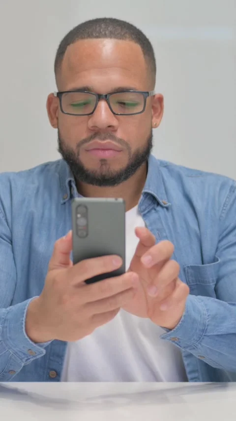 Mixed Race Man Browsing Internet on Phone, vertical video Stock Footage 325712814