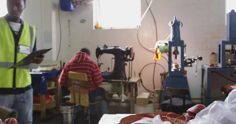 Mixed race man checking work quality in factory Stock Footage 124590449