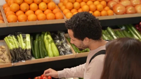 Mixed race man taking tomatoes in supermarket Video stock 157174550