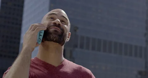 Mixed race man talks on phone and looks around in big city 4K Stock Footage 64644572