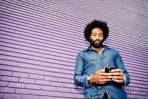 Mixed race man using cell phone outdoors Stock Photos