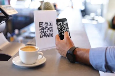 Mixed race man using smartphone and reading qr code in cafe Stock Photos