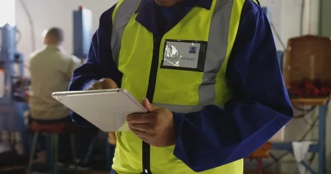 Mixed race man using tablet computer in factory Stock Footage 124590371