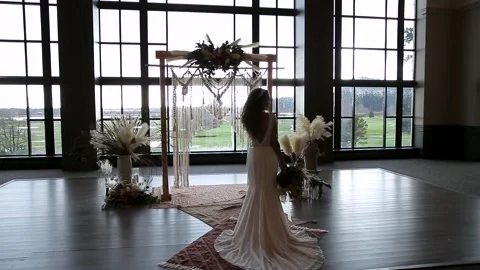 Mixed race modern bride with a wedding bouquet silhouetted against a wedding Stock Footage 150710423