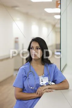Mixed Race Nurse Standing In Hospital Corridor