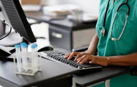 Mixed race nurse working at computer 库存照片