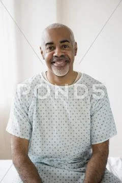 Mixed Race Older Man Sitting On Hospital Bed